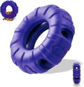 Blue rubber tyre-shaped dog chew toy and slow feeder with oval openings on a wooden floor.