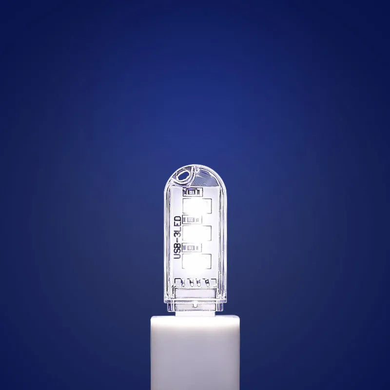 Small white USB-powered LED baby night light with eye protection, shown next to a USB cable for scale.