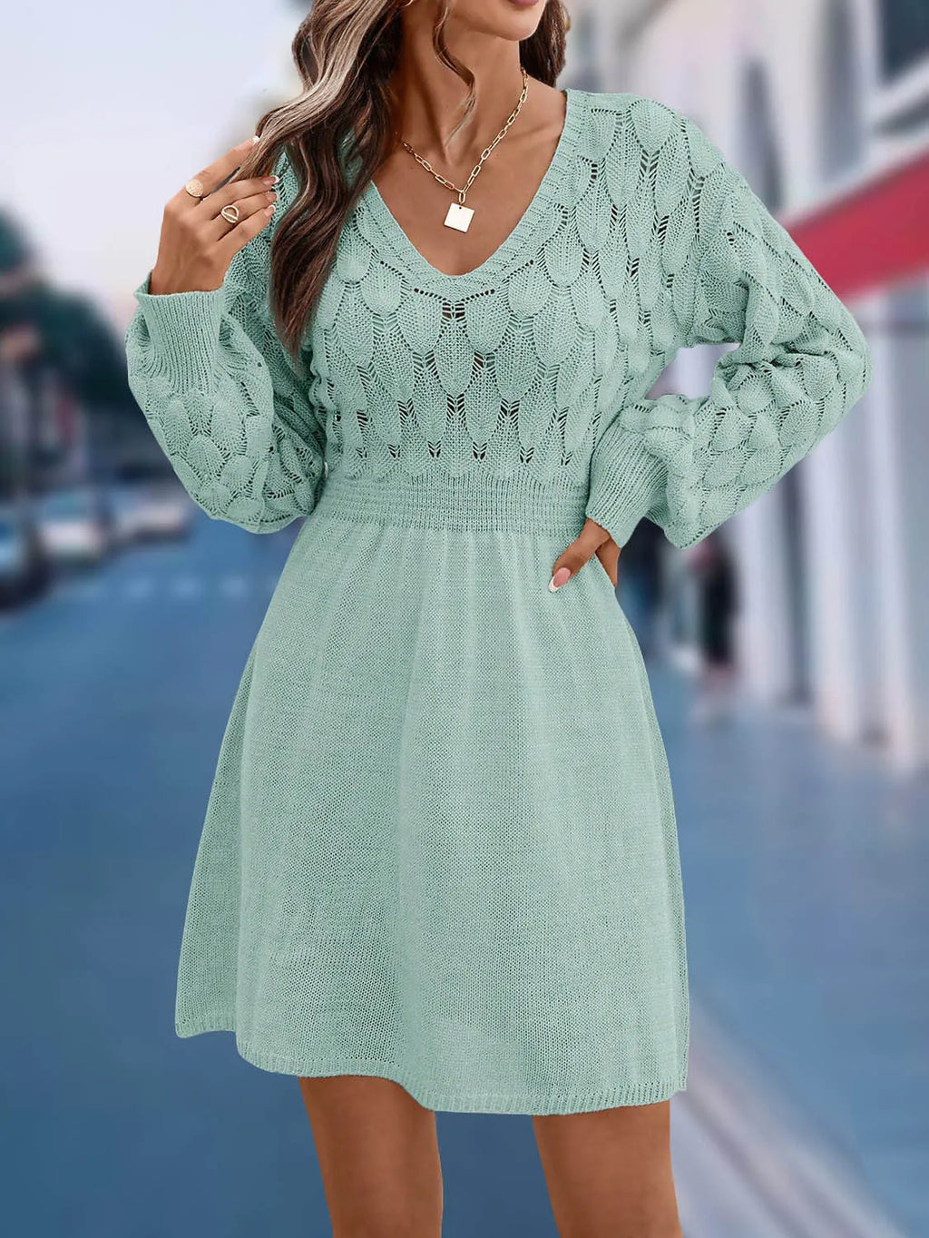 Long sleeve v-neck dress in apricot with artistic 3D pattern details and a high-waisted midi silhouette.