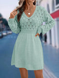 Long sleeve v-neck dress in apricot with artistic 3D pattern details and a high-waisted midi silhouette.
