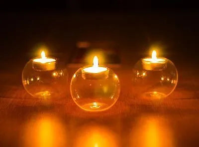 Clear handmade round hollow glass candleholder on a table.