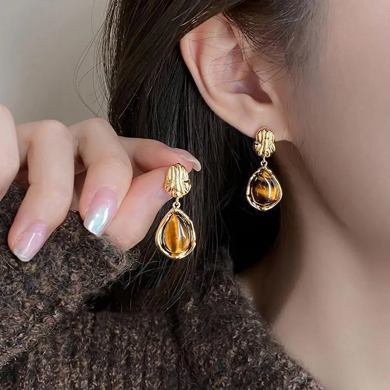Three pairs of handmade geometric holiday earrings with tassels: irregular, water drop, and round designs.