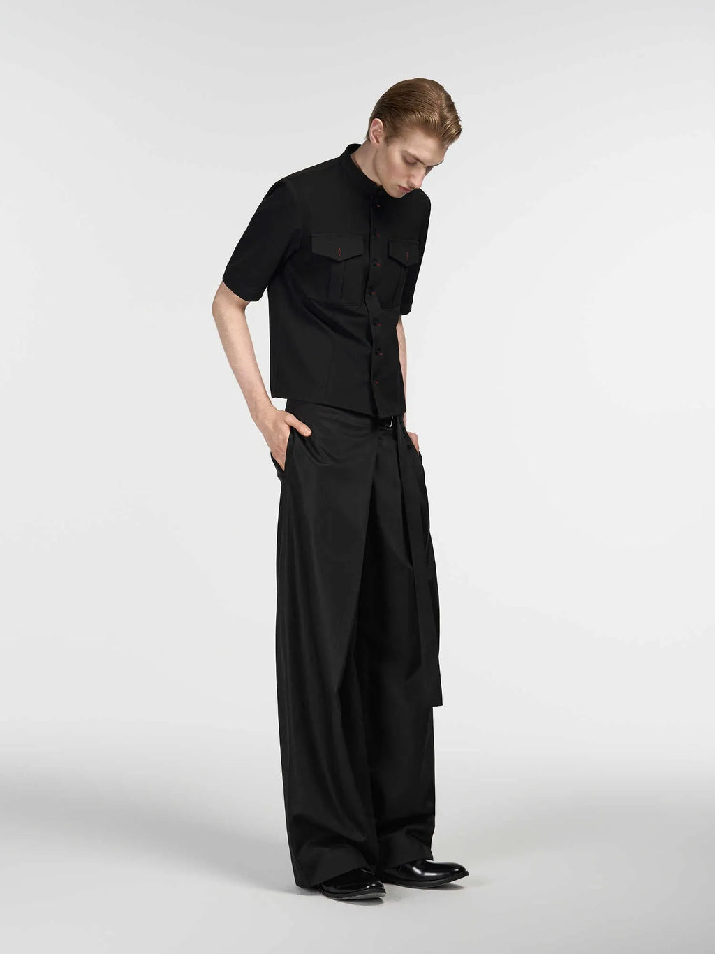 Black straight-leg trousers with a single pleat and adjustable waistband on a plain background.