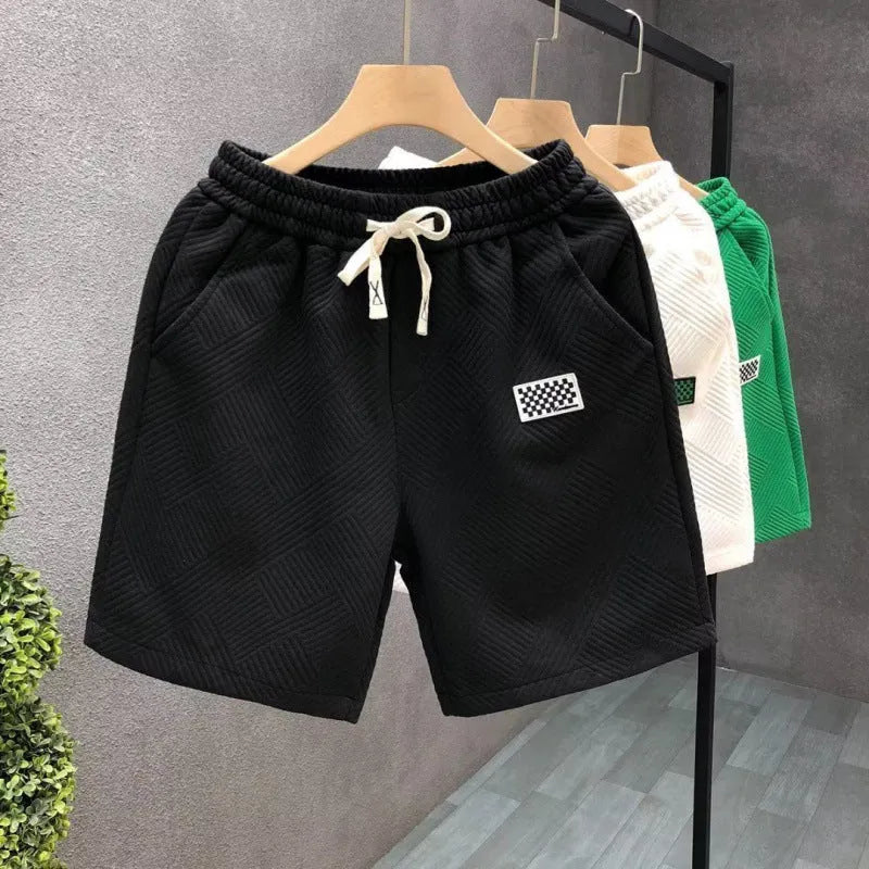 Solid colour polyester sports shorts with elastic waist on a mannequin, shown in black.
