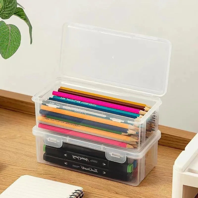 Transparent plastic stationery storage box with pencils and crayons inside