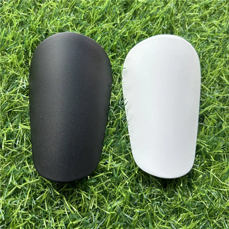 A pair of extra small mini plastic football shin guards, shown in either black or white.