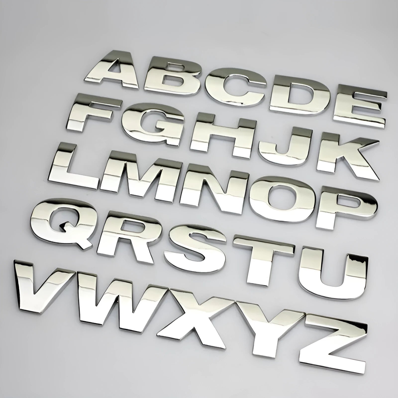 3D metal zinc alloy car bumper sticker showing a raised English letter on adhesive backing.