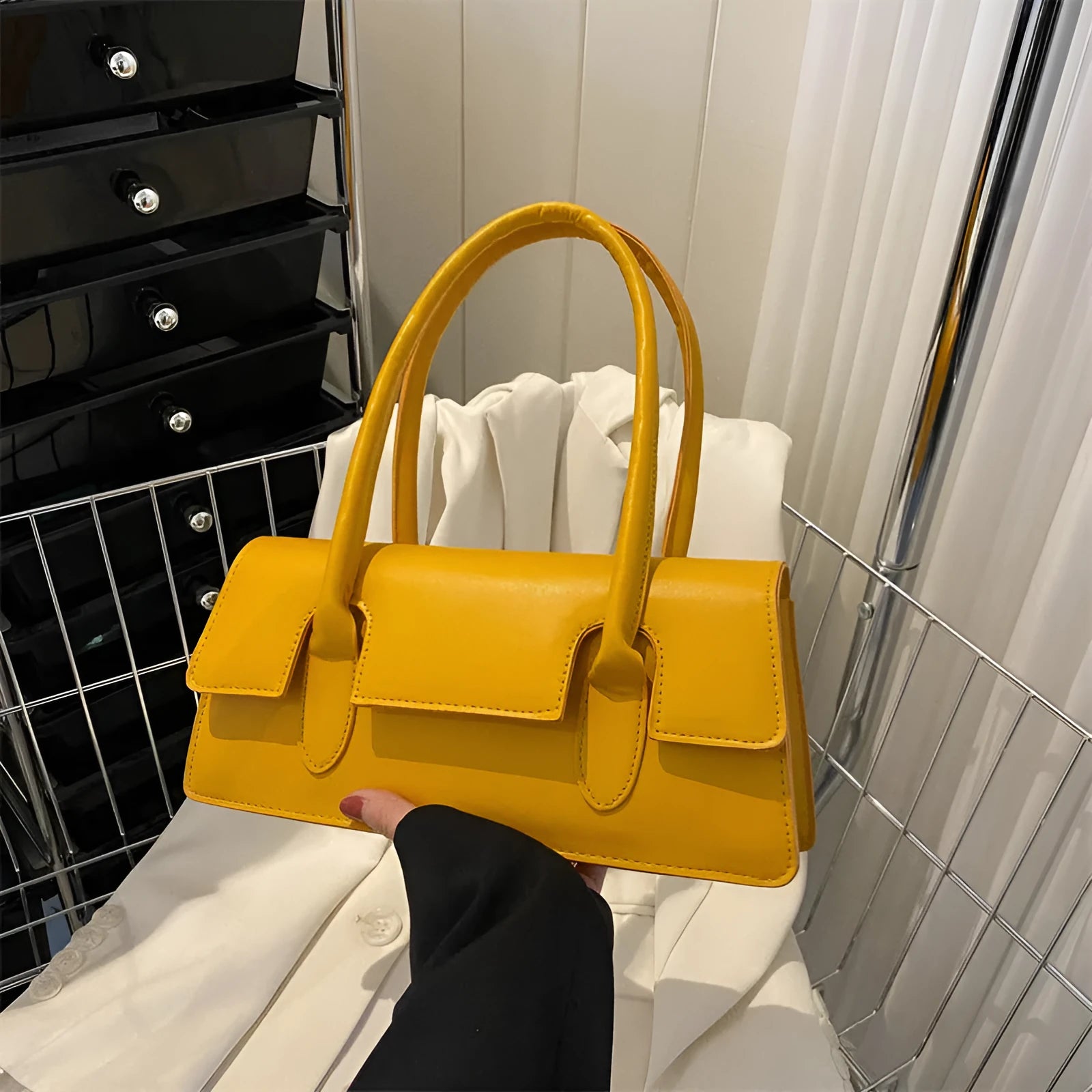 Women's small square shoulder bag in PU material showing stitching details and horizontal shape