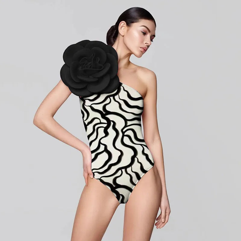 Women's black one-piece swimsuit with three-dimensional white floral pattern, showcasing European/American fit.