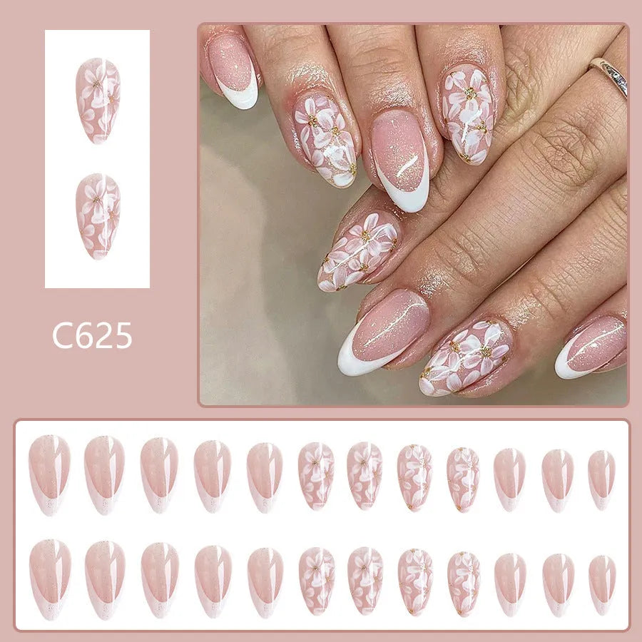 Short glossy almond-shaped false nails with glitter and flower French tip design, colour C625.
