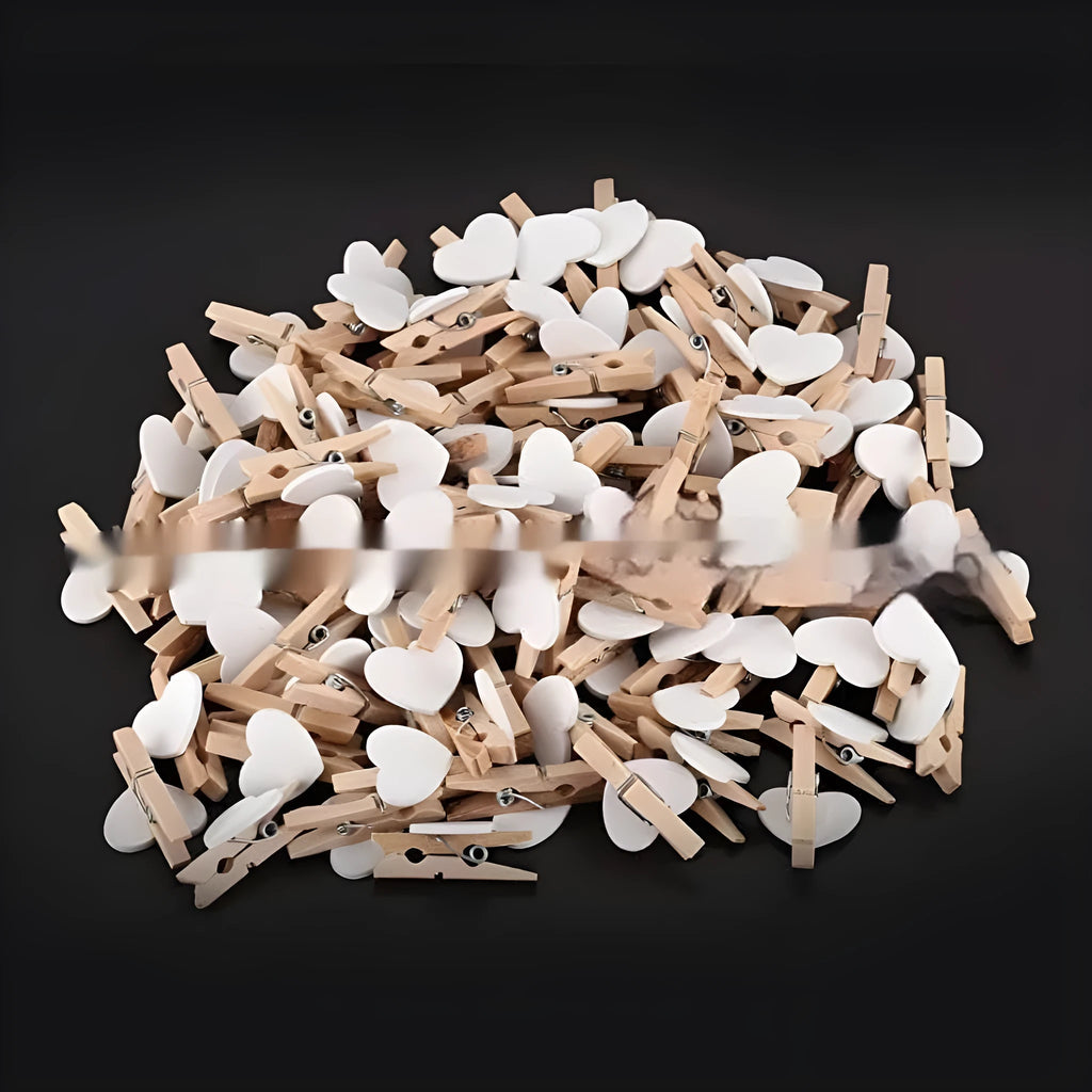 Set of five handmade solid wood heart-shaped clips in red, white, and rose red on a wooden surface.