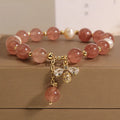 Women's freshwater pearl and strawberry quartz bracelet with zircon accents on wrist