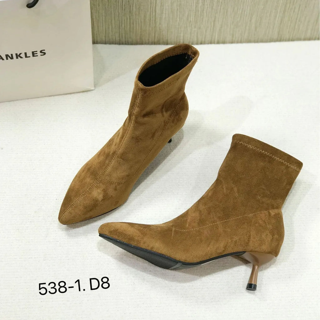 Black pointed toe ankle boots with high stiletto heel and mid-calf shaft showing microfiber texture