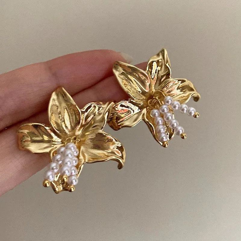 A pair of gold H1795 flower-shaped earrings for women with a Seiko-treated metal finish.
