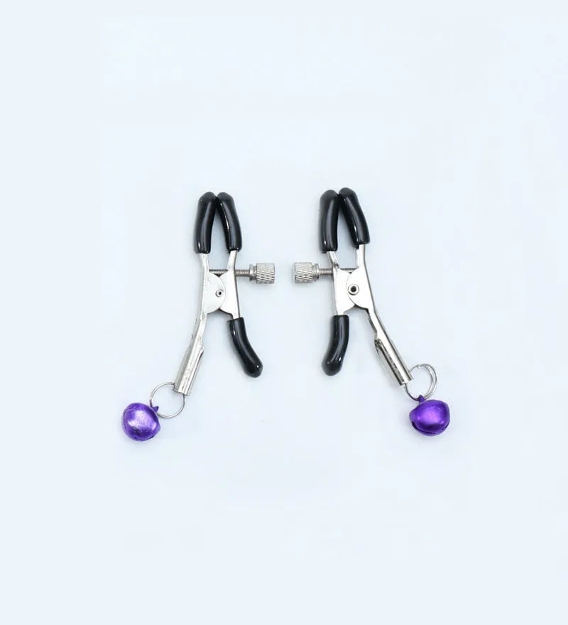 Red bell nipple clamp pair with chain attachment on a dark background