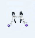Red bell nipple clamp pair with chain attachment on a dark background