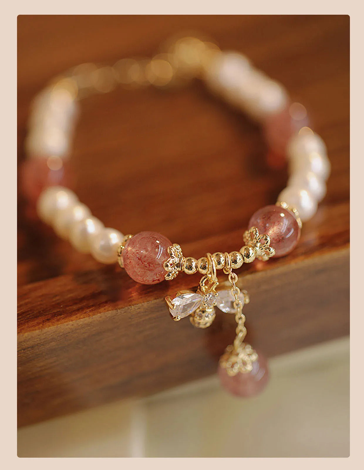 Women's handmade strawberry quartz crystal bracelet with stringed pearls and bow decoration