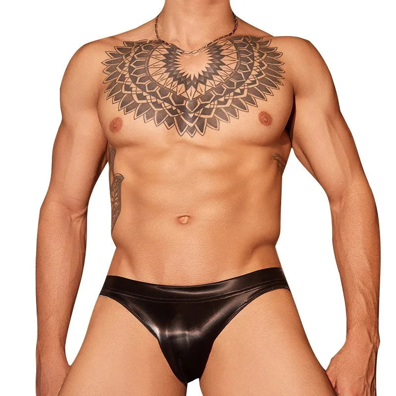 Men's black hipster briefs made from textured shark skin lace fabric on a grey background.