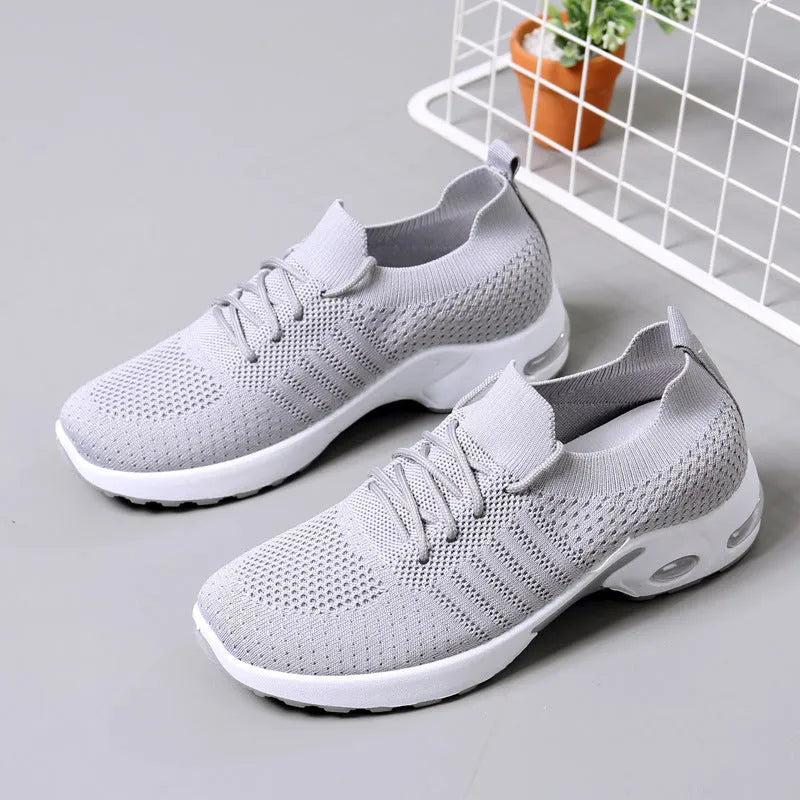 Women's black mesh sneakers with a soft sole and round toe, shown with lace-up front closure.