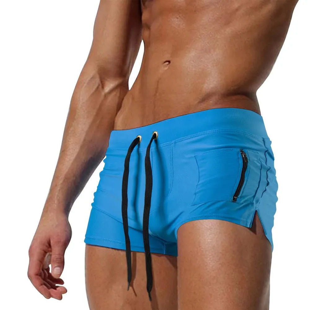 Men's solid colour polyester swimming trunks with lace-up waistband shown in black, dark blue, white, and red options