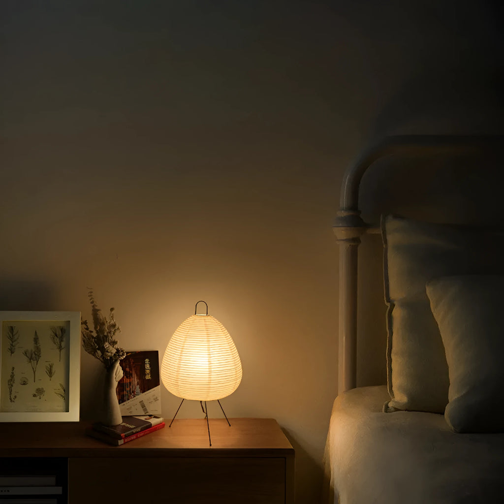 Japanese style handmade rice paper table lamp with an aluminium base on a wooden table.