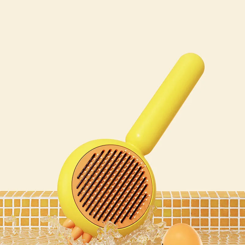 Purple and white self-cleaning pet grooming brush with bent stainless steel bristles on a wooden table.
