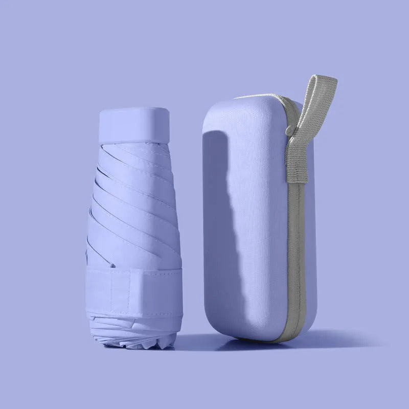 Six-fold manual umbrella in sky blue with capsule box storage, showing compact folded size and rubber handle