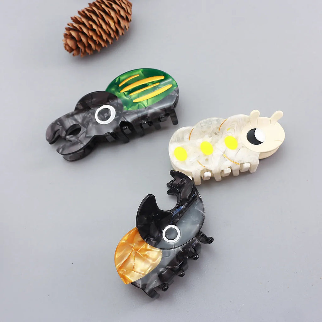 Handmade green and orange beetle grip hair accessory with white cartoon caterpillar design