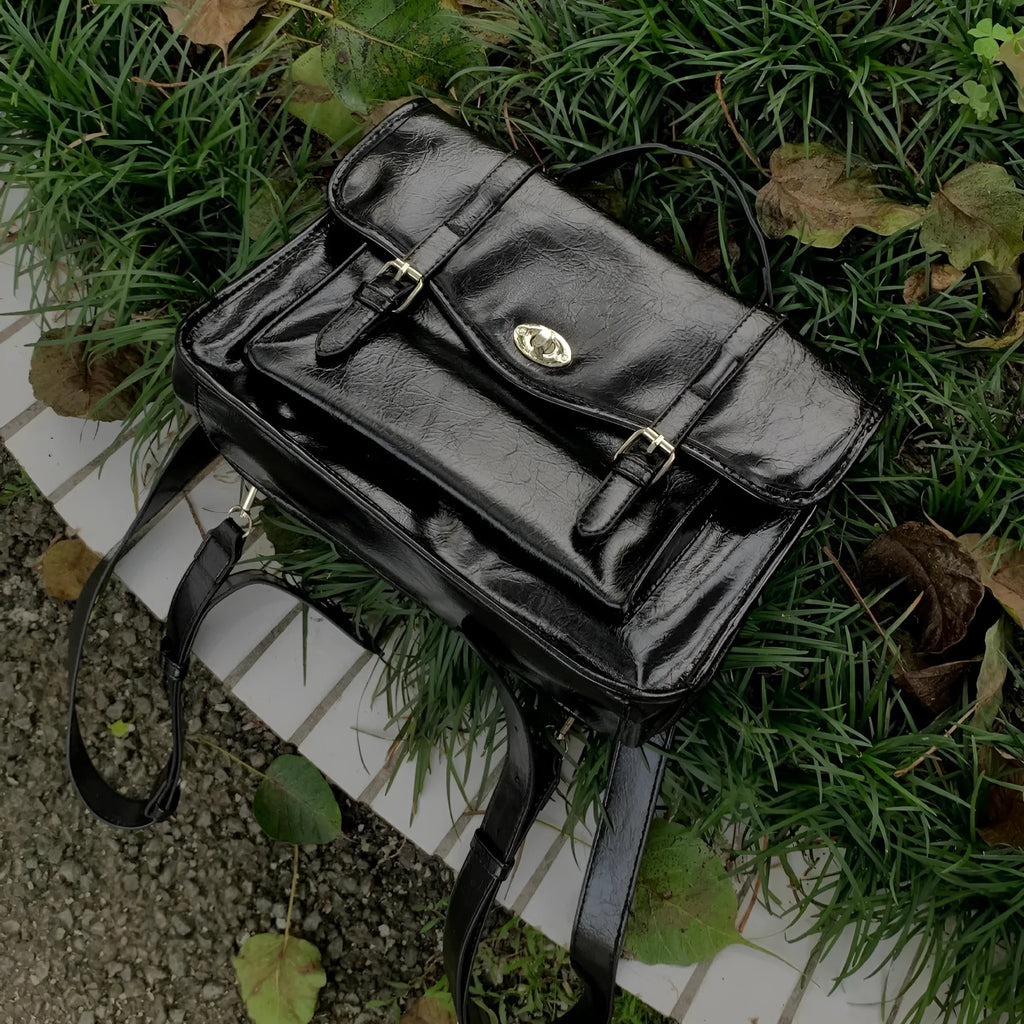 Black college style messenger bag for women made from oil wax leather-look PU material.