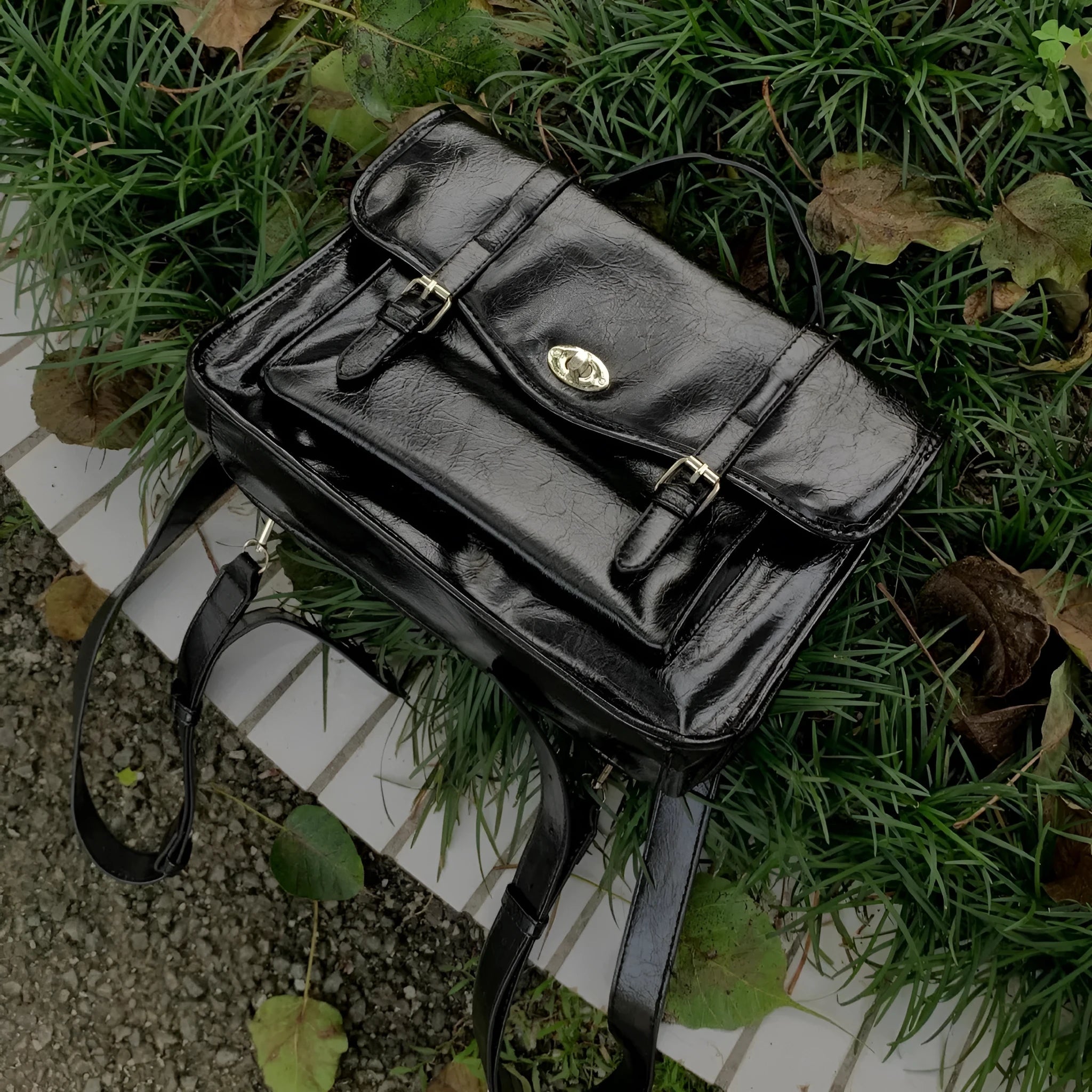 Black college style messenger bag for women made from oil wax leather-look PU material.