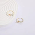 Geometric triangle birthstone ring with tricolour zircon and horse eye motif in gold plating.