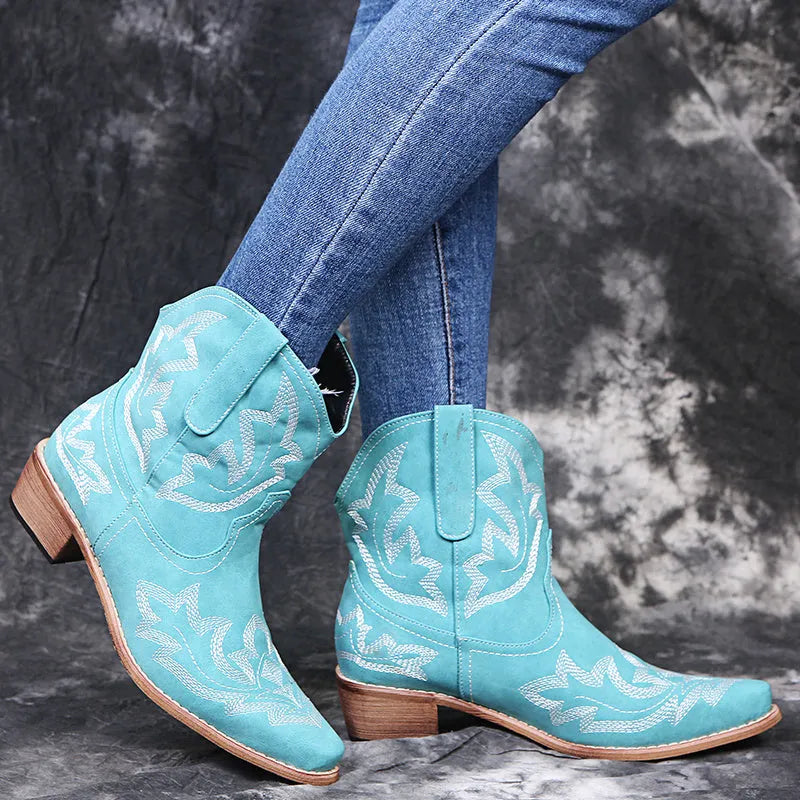 Women's blue cowboy boots with wedge heel, pointed toe, and embroidery details on low canister.