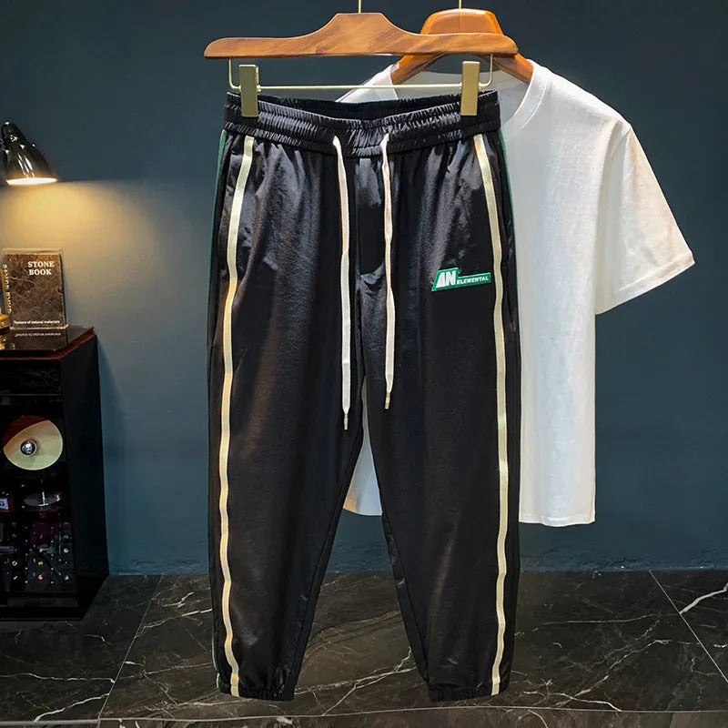 Men's black cotton ice silk harem trousers showing mid-waist design and full-length legs