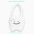 White plush tote bag with tooth decoration and shoulder strap showing zip opening
