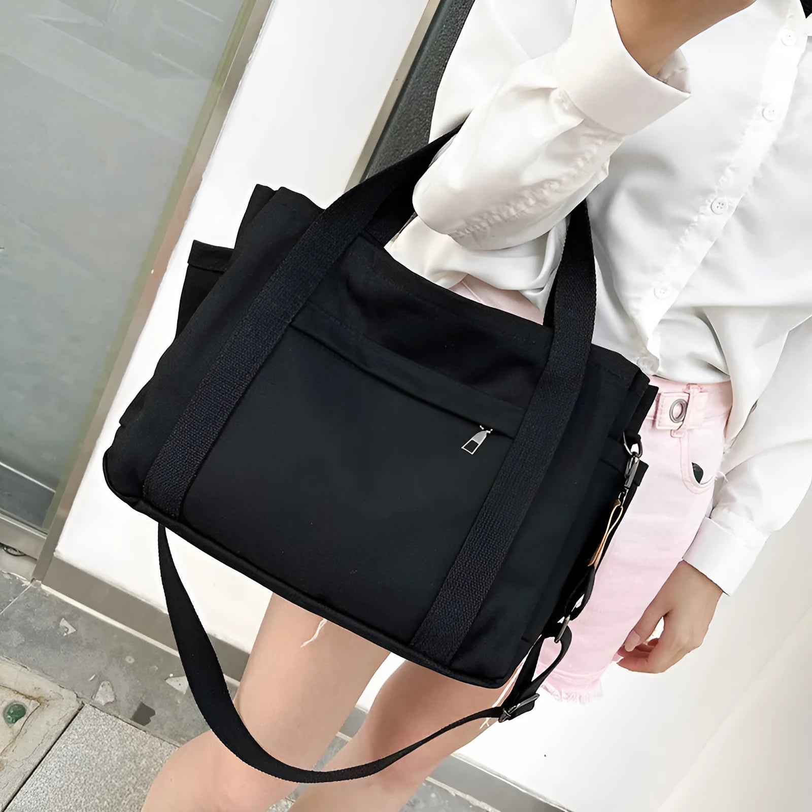 Army green canvas tote bag with open zip sides showing internal laptop and camera pockets.