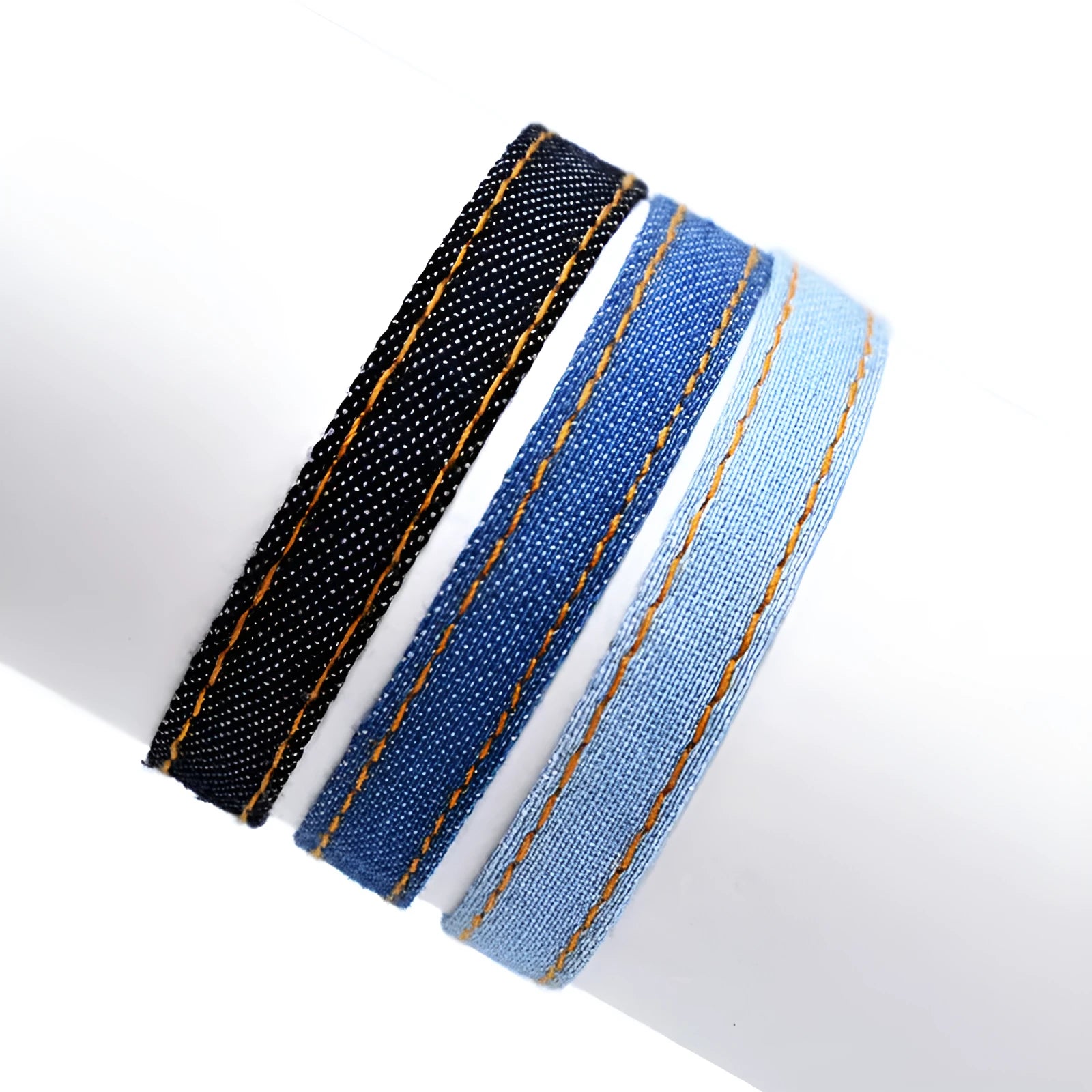 Denim fabric bracelet carrying strap showing mixed material construction and traditional closure mechanism