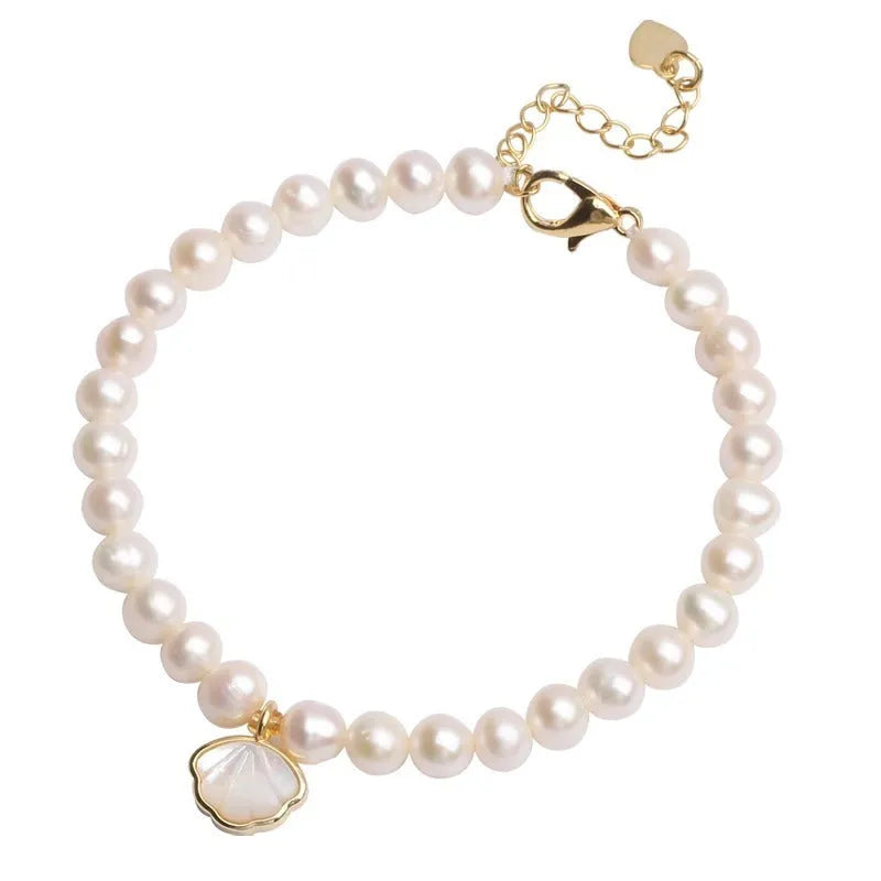 Women's freshwater pearl bracelet with fan-shaped design on wrist, showing elastic and chain fastening options.