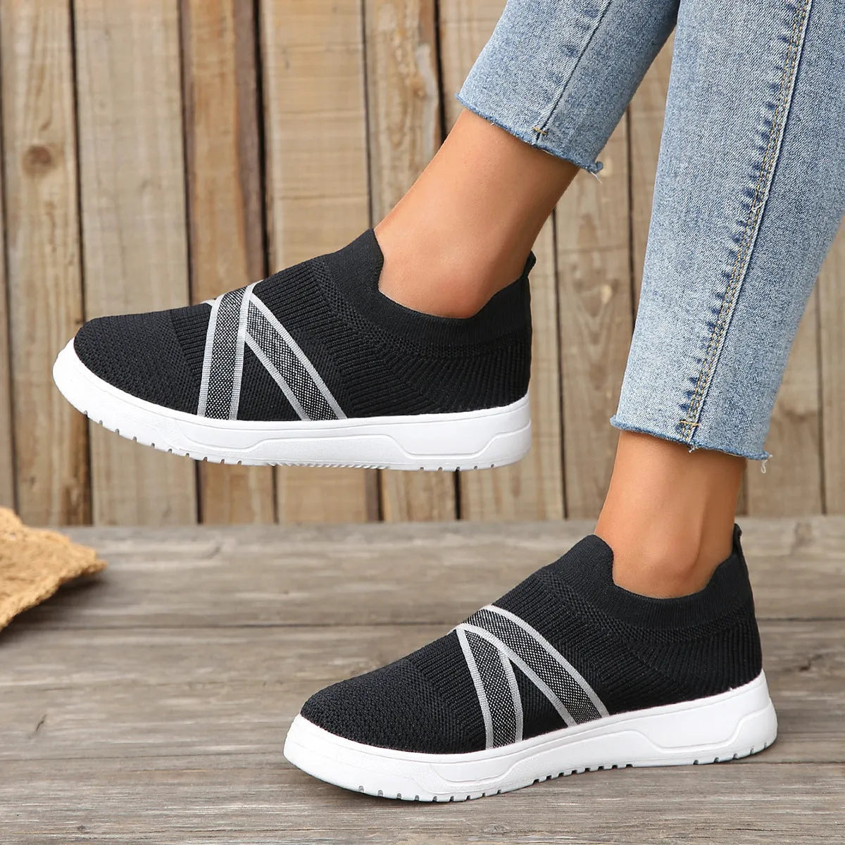 Black women's Flyknit mesh flat shoes with a tassel detail on the low-top upper and a flat rubber sole.