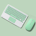 Pink wireless Bluetooth touch keyboard and rechargeable mouse set with charging cable on a desk
