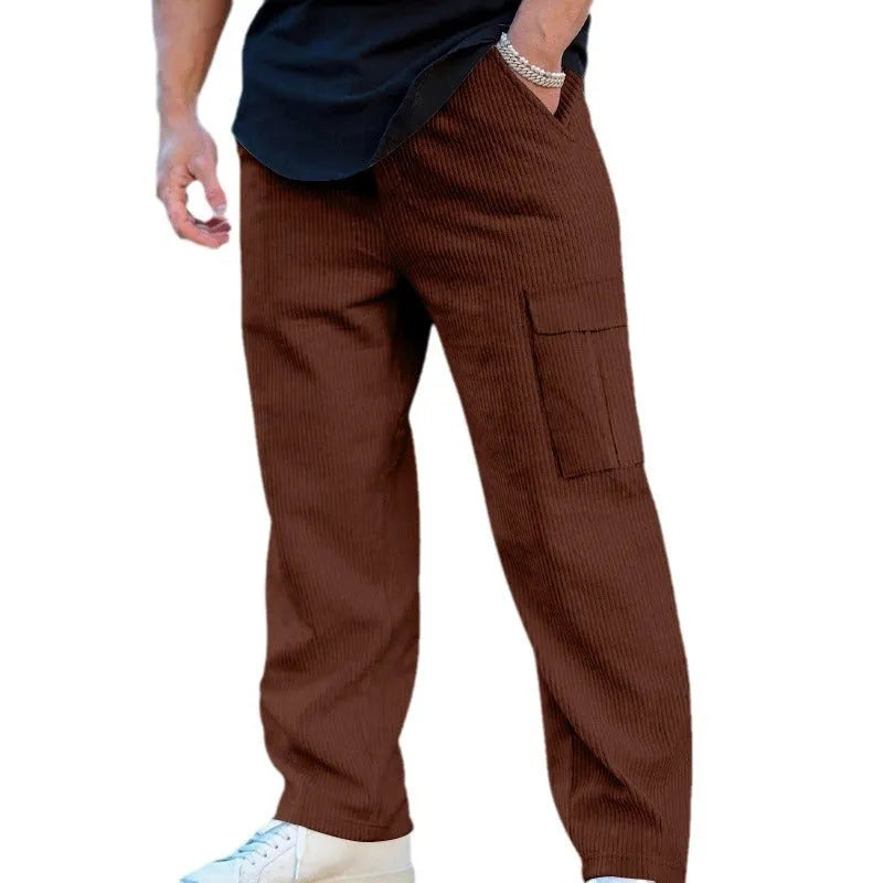 Man wearing navy blue loose-fitting corduroy cargo trousers with a drawstring waist and straight wide legs.