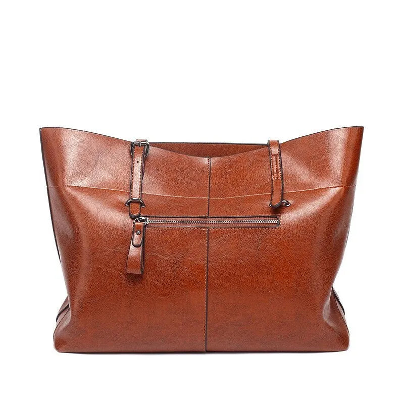 Brown leather crossbody handbag showing two main compartments and a front phone pouch