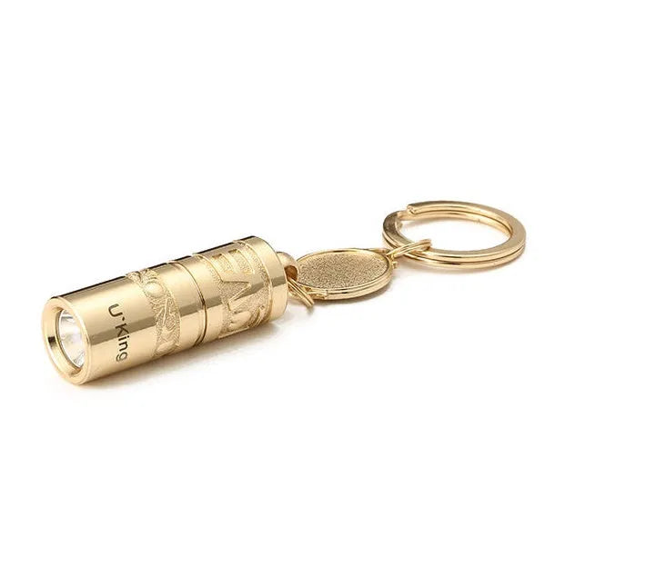 Gold-coloured waterproof mini LED keychain flashlight with zinc alloy housing on a key ring.