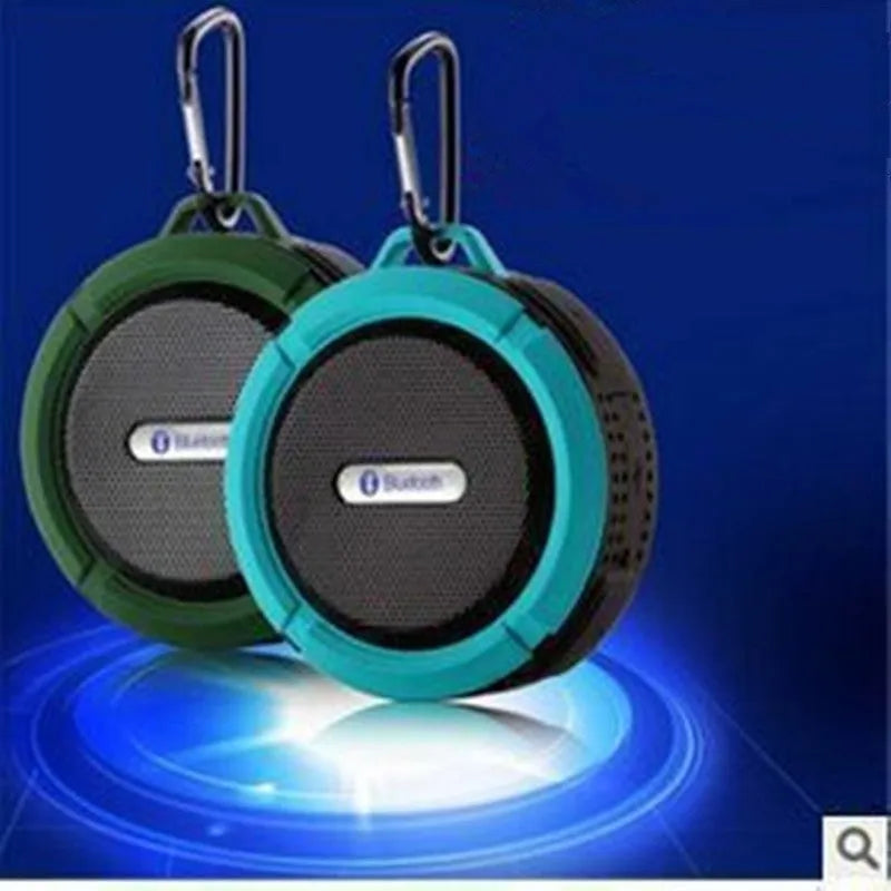 Compact portable Bluetooth stereo speaker with mountaineering buckle, shown in multiple colour options.