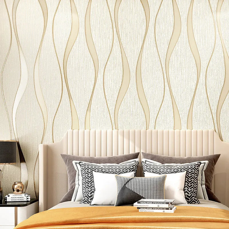 Roll of grey 3D curve stripe textured velvet wallpaper against a wall.