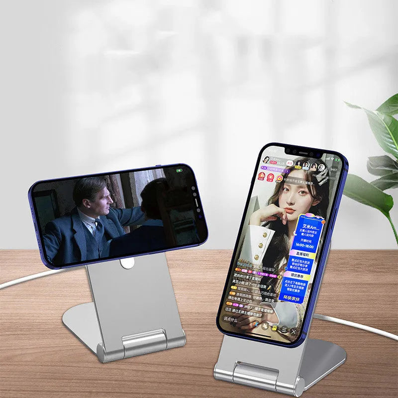Silver portable magnetic bracket for iPhone 12, showing adjustable vertical stand on a desk.