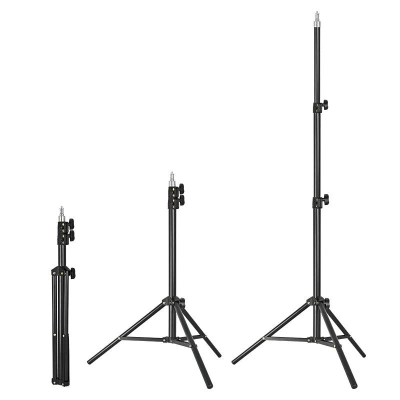 Tall black floor tripod stand holding a mobile phone extended to its full height on a wooden floor.