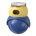 Yellow and blue plastic tumbler-style cat feeder puzzle toy on a floor.