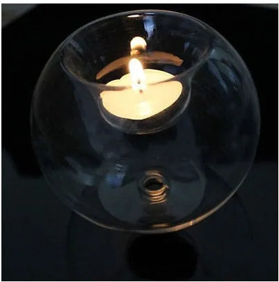 Clear handmade round hollow glass candleholder on a table.