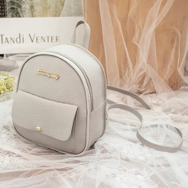 Small black PU women's backpack with shoulder strap showing compact dimensions