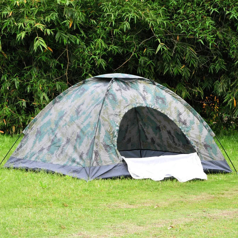 Green camouflage two-person camping tent with fibreglass poles pitched outdoors